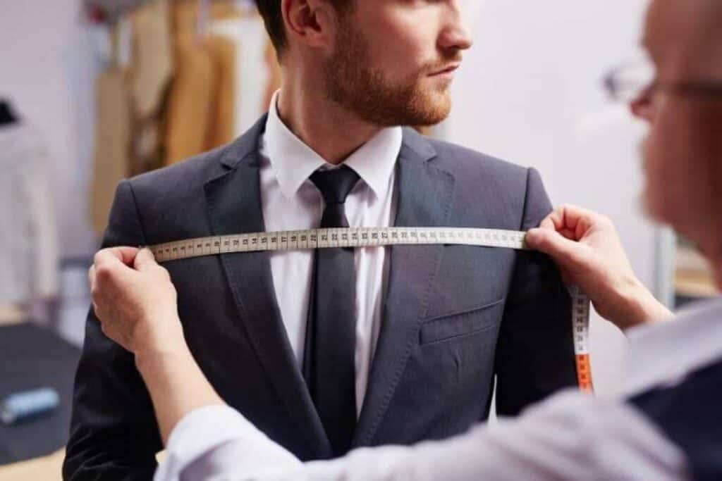 Tailor measuring chest width with tailor's tape
